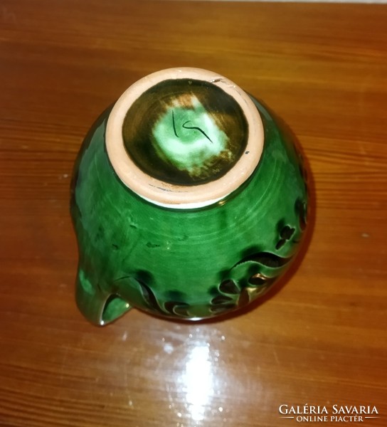 Folk green ceramic jug pouring
