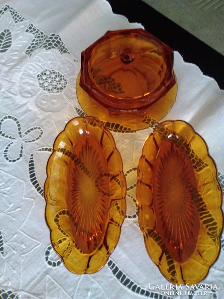 Amber octagonal glass butter holder with two wavy edges, together.