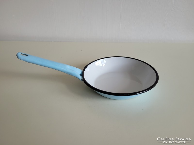 Old vintage blue frying pan with white handle