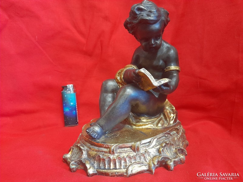 Baroque putto, figural statue of a book support reading an angel book.