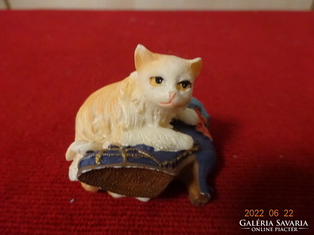 A brown-haired cat figurine lying on a woman's boots. He has! Jókai.