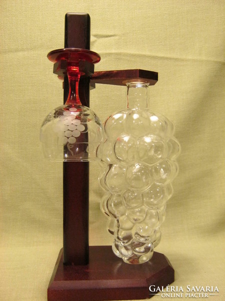 Bottle of wine set with bunch of grapes in a bottle and 2 goblets on a stand