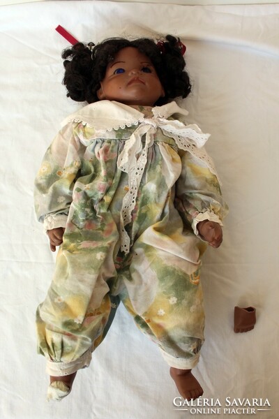 A negro doll with a porcelain head and body is injured