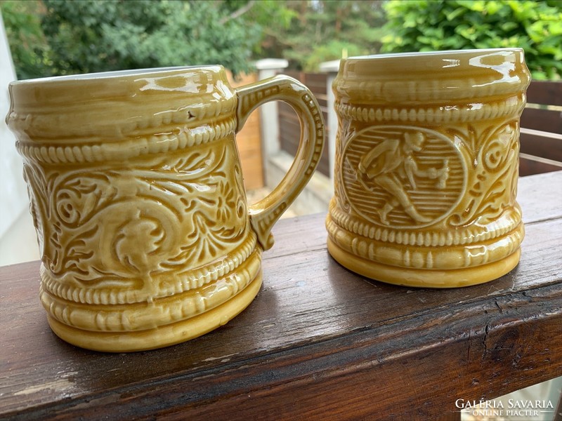 Pair of granite mugs/jugs with cheeky pointed human depictions, 2 pcs. Mustard yellow