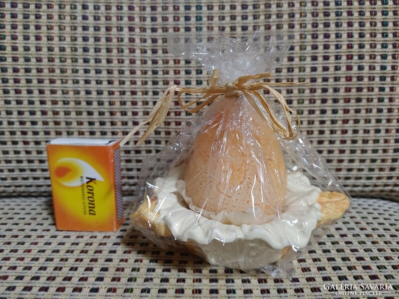 Egg-shaped candle with candle holder.