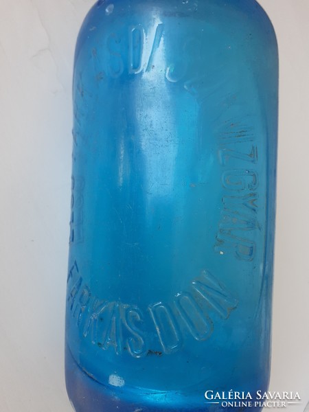 Old blue soda bottle soda bottle with inscription on the front of the wolf factory in Farkas