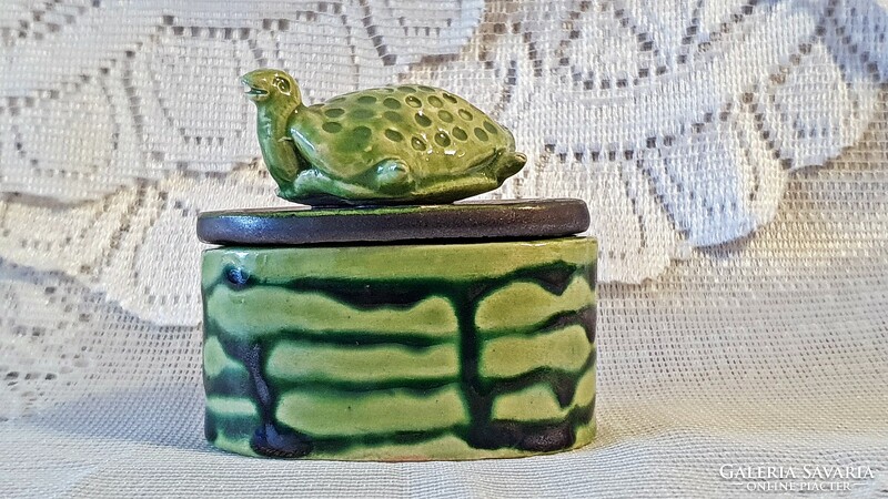 Old, oval-shaped, green, ceramic bonbonier with a tortoise figure on top.
