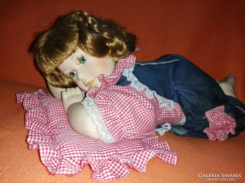 Porcelain doll lying on her stomach with elbows, vintage doll.