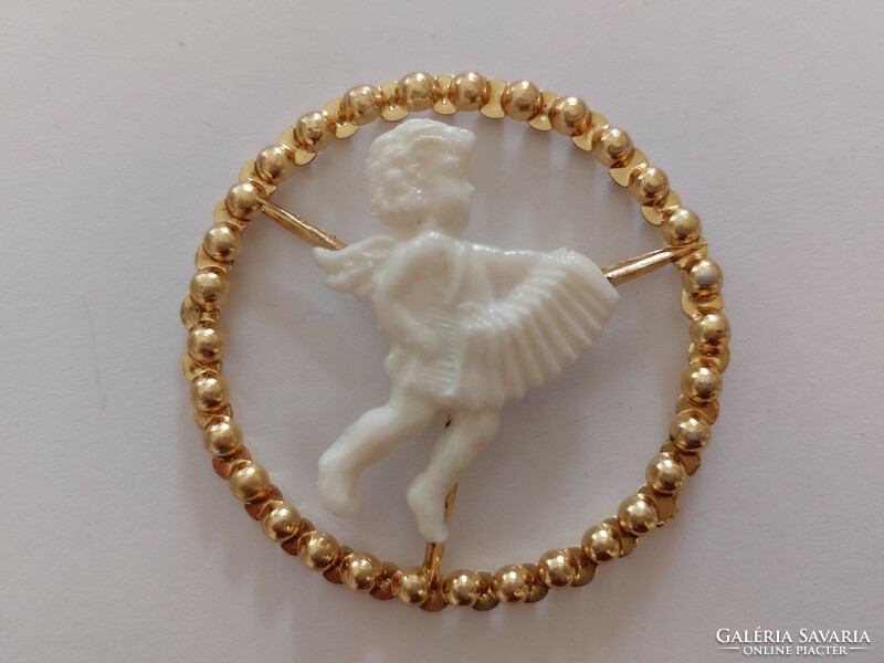 Old plastic Christmas tree decoration with a musical angel in a golden ring