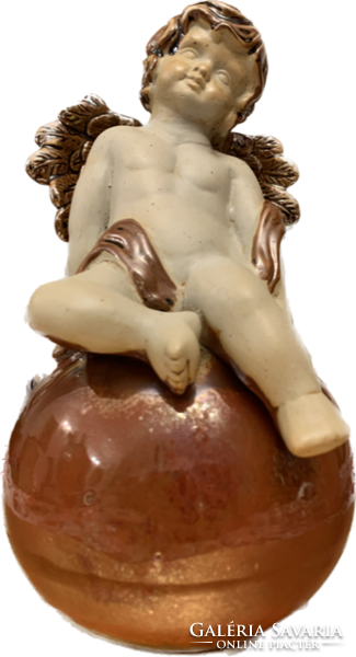 Porcelain angel sitting on an eosin-glazed globe