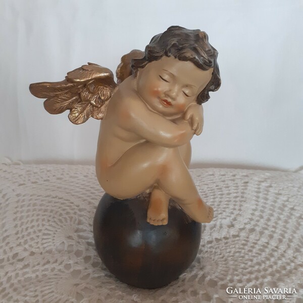 Angel sitting on a sphere, with golden wings, decoration