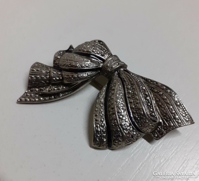 A silver-colored bow-shaped brooch in nice condition