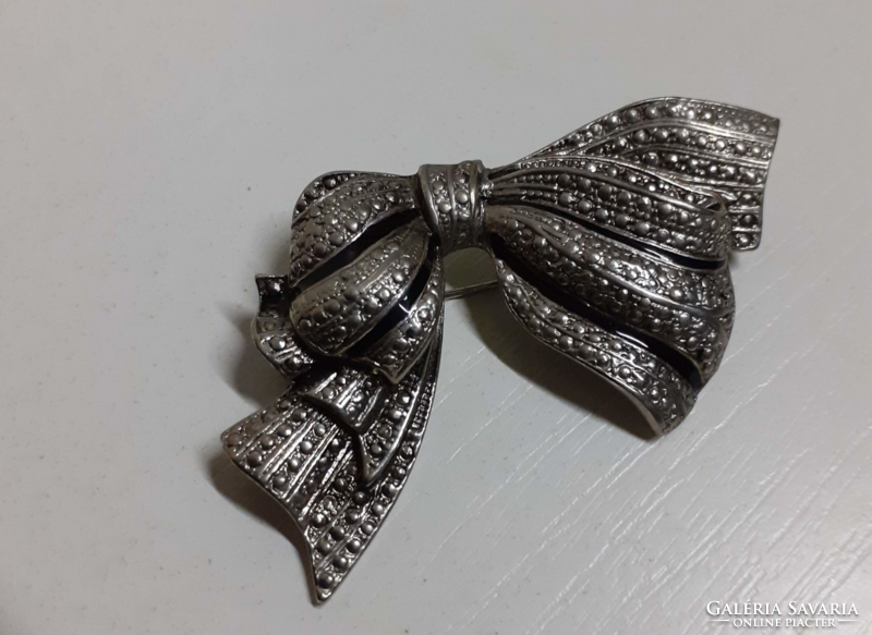 A silver-colored bow-shaped brooch in nice condition