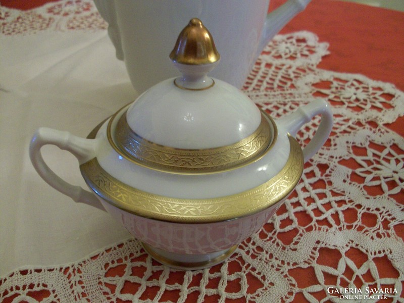 Porcelain teapot with a beautiful golden border, on a snow-white base, sugar holder and milk spout