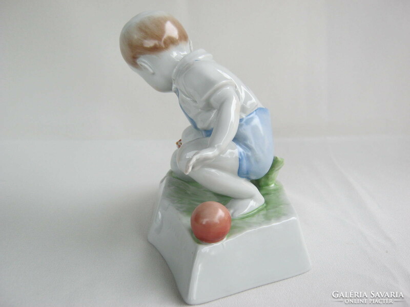 Little boy stroking Zsolnay porcelain hen