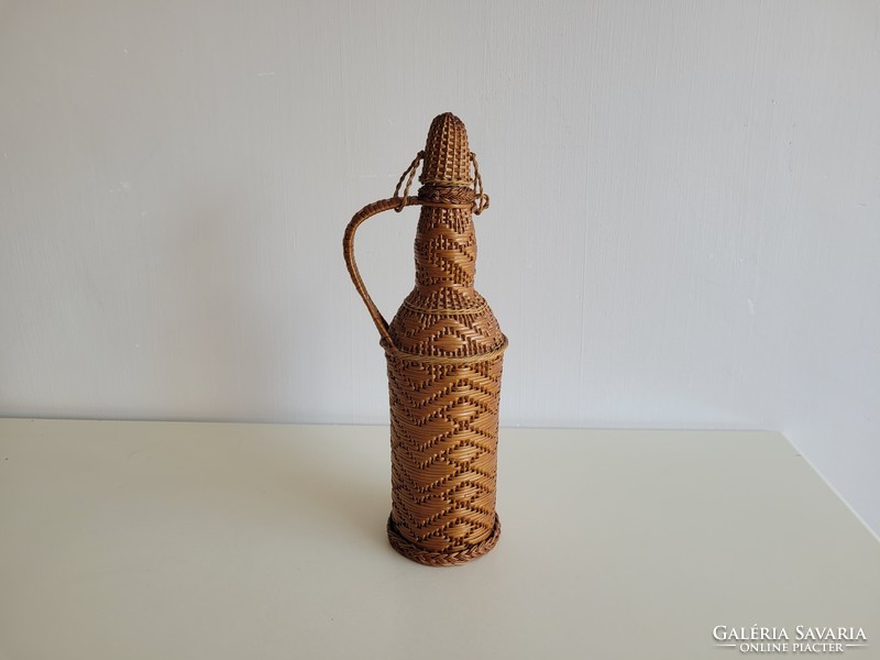 Old retro woven 1 l glass bottle with wine brandy in a small demizon