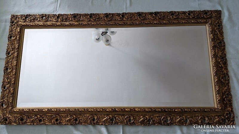 Polished mirror (faceted) in a large, elegant frame.