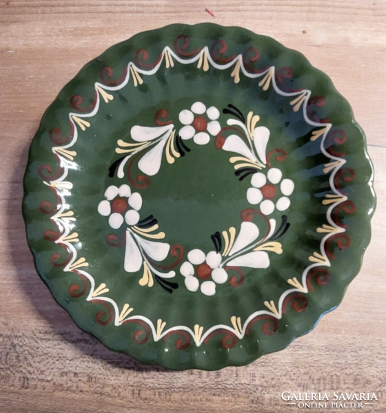 Ceramic wall decoration with white flowers on a green background marked J9, wall plate diameter 19 cm
