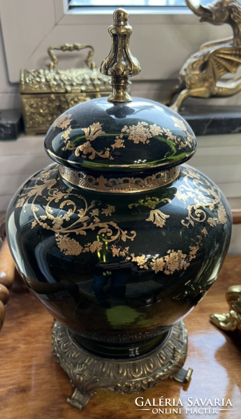 A gilded glass vase with a lid on a bronze base and with tongs
