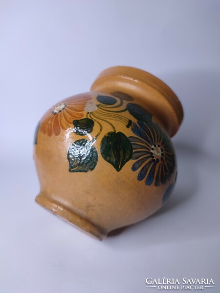 Old small-scale painted folk earthenware pot with silk flowers