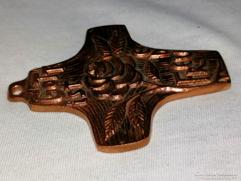A bronze cross that can be hung on the wall for collection