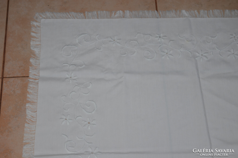 Center table with white embroidery on a white background