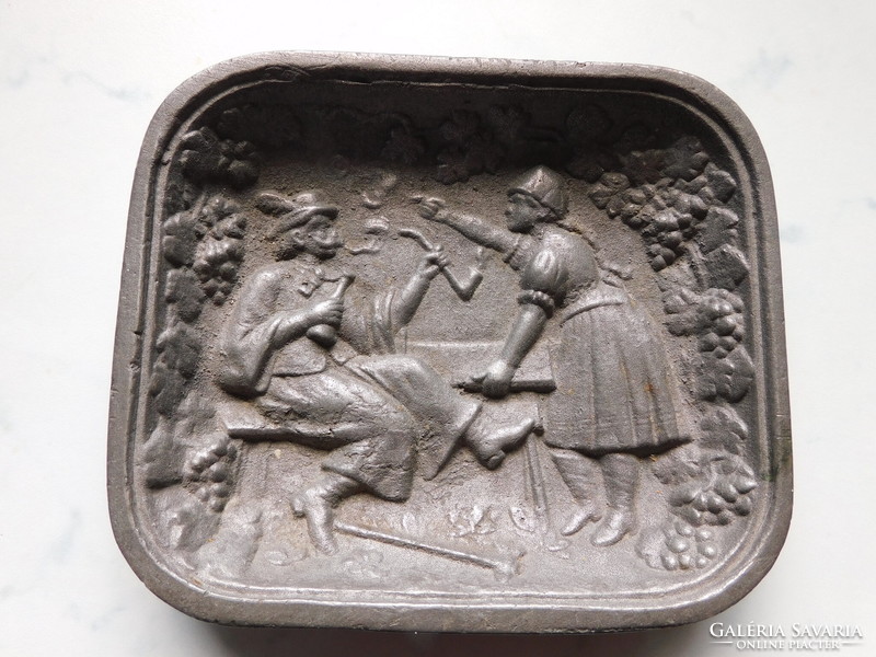 Old cast-iron bowl with a litigious couple in folk costume
