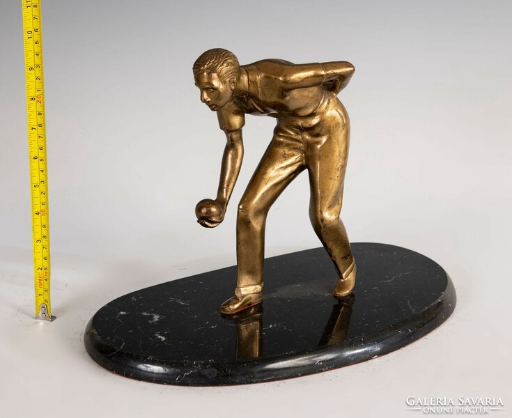 Statue of a bowling man on a marble base