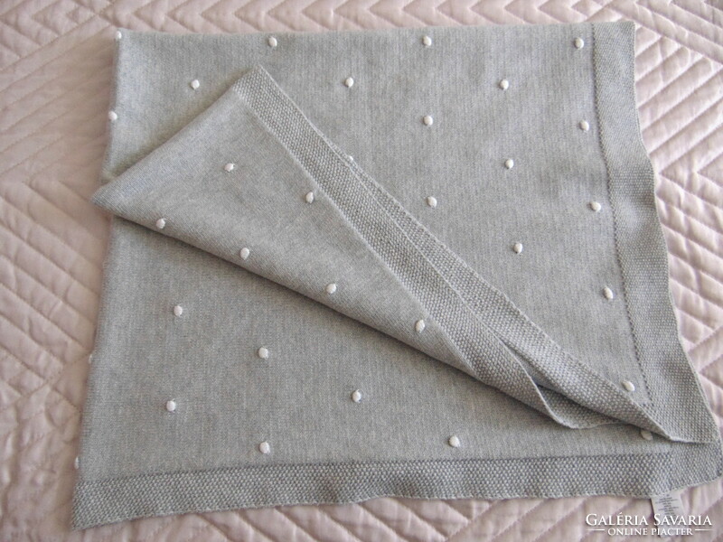 100% cotton knitted baby blanket with white dots on a gray background