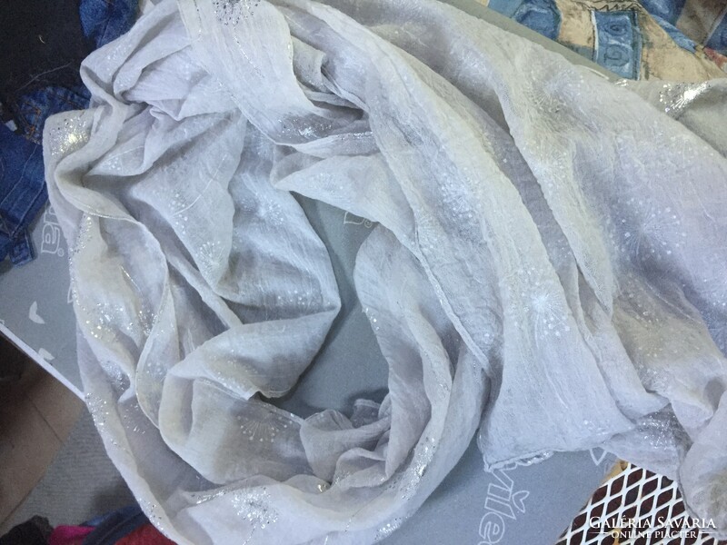 A very feminine pale gray thin scarf with a silver pattern