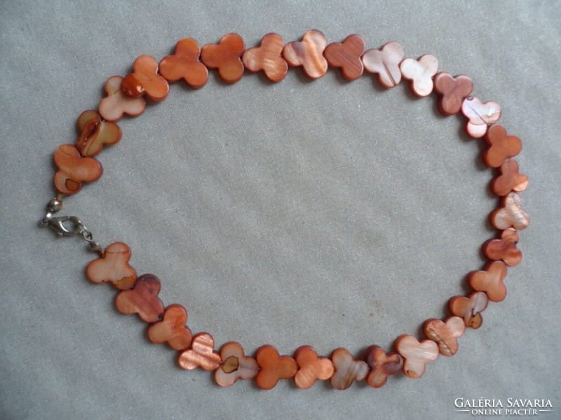 A necklace or bracelet made of flat brownish mother-of-pearl pieces