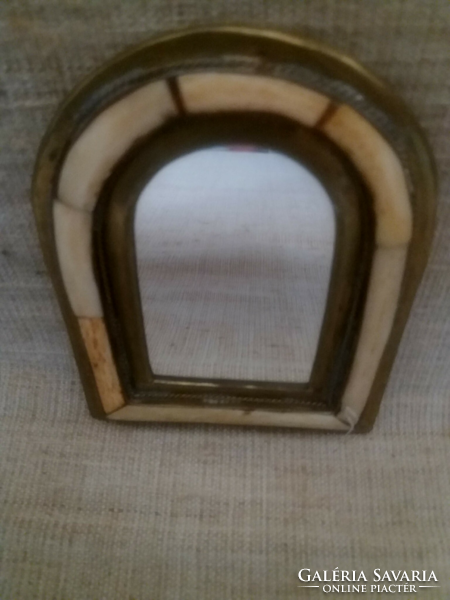 A small wall-hanging mirror with a brass bone inlay frame