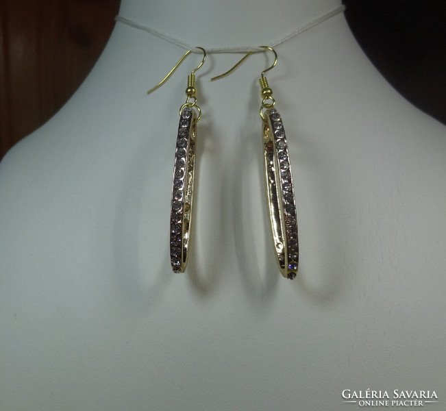 Oval gold-colored earrings with crystal stones
