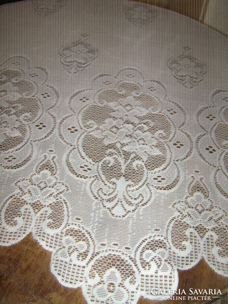 A beautiful openwork floral patterned curtain with a wavy bottom