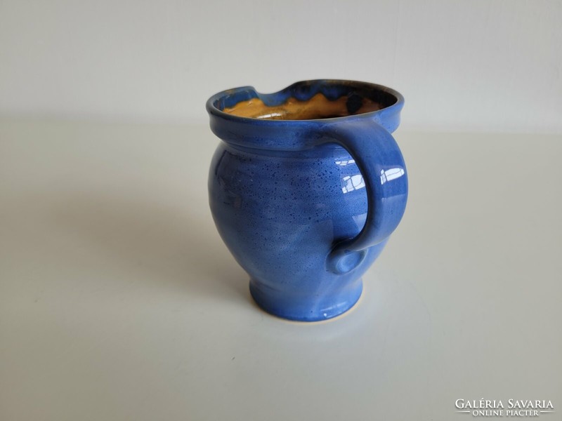 Glazed ceramic jug with blue small spout