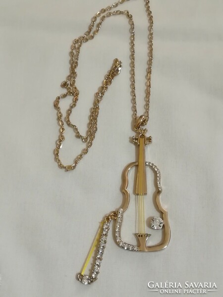 Musical instrument pendant on a long chain.