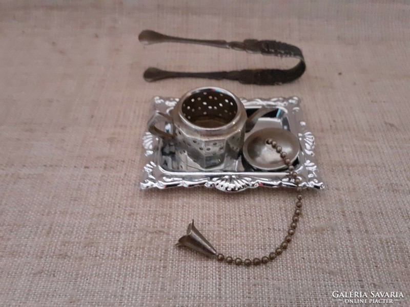 Retro teapot-shaped tea egg on a small patterned metal tray with rose-patterned sugar tongs