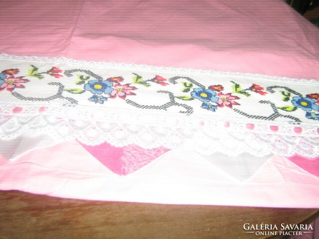 A beautiful pink quilt cover with a cross-stitched flower insert