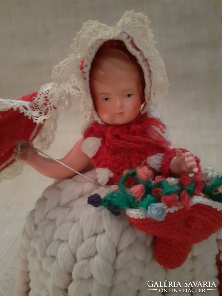 Old baby in a nice knitted crocheted dress holding an umbrella and a small crocheted bag