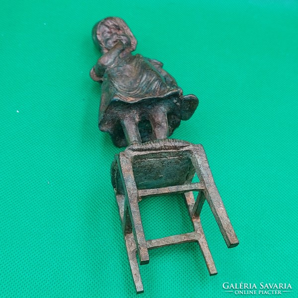 Statue of a little girl standing on a chair