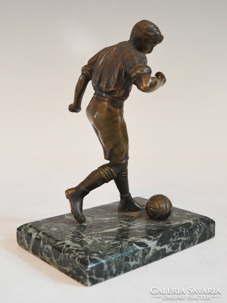 Bronze football player statue on a marble plinth