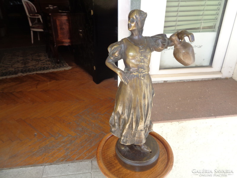 Bronz szobor, korsót tartó asszony