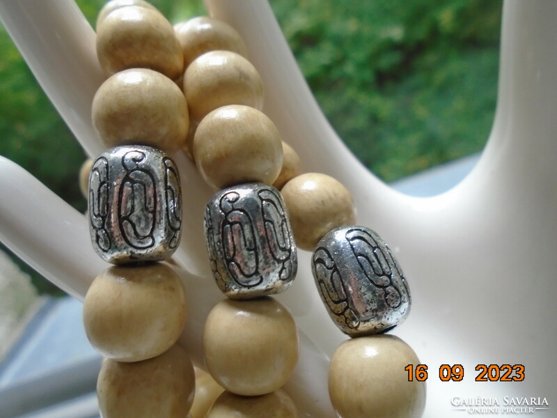 Természetes hatású bézs gyönggyökből 3 db összekapcsolt karkotő ezüstözött charmokkal,díszgyönggyel