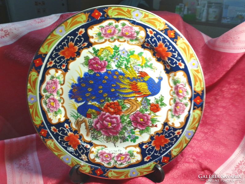 A beautiful porcelain decorative plate with a peacock pattern
