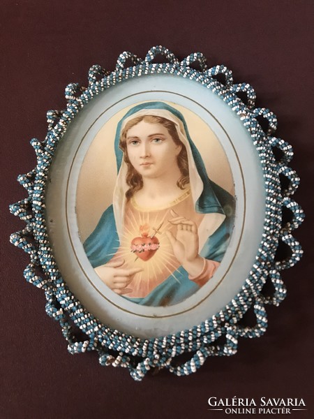 Saint image wrapped around the edge with pearls. Painted on glass