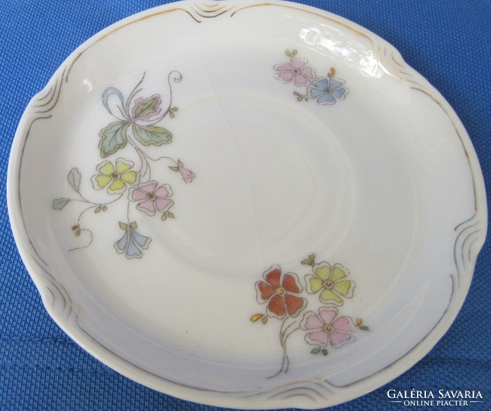 Older porcelain coffee set of 4 with a flower pattern, marked, slightly defective, one plate cracked.