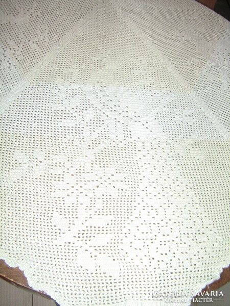 Beautiful light blue-green crocheted round tablecloth with peacocks