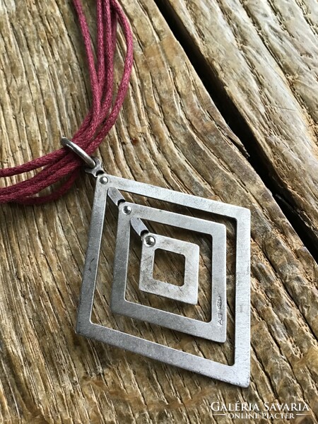 Silver pendant with silver fittings on a cord necklace