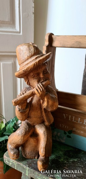 Carved wooden statue, a boy playing a flute