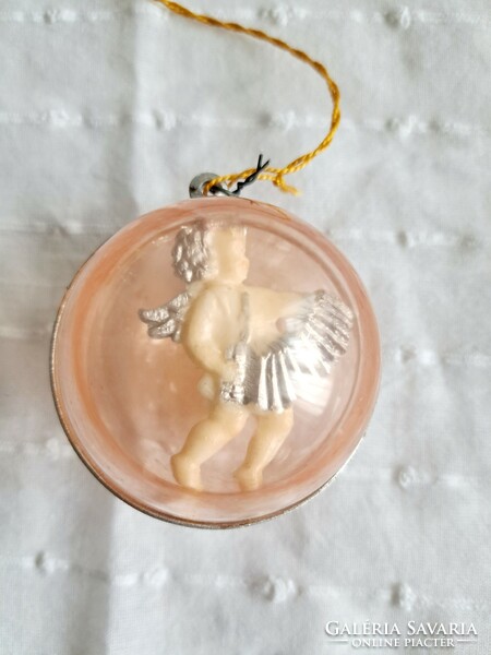An old Christmas tree ornament with an angel playing an accordion